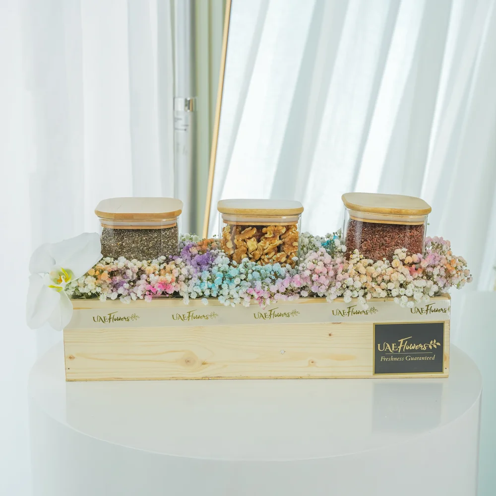 Collection of white cymbidium orchid, Chia seeds, Walnuts, Flax seeds and pastel colored baby's breath around the wooden box.