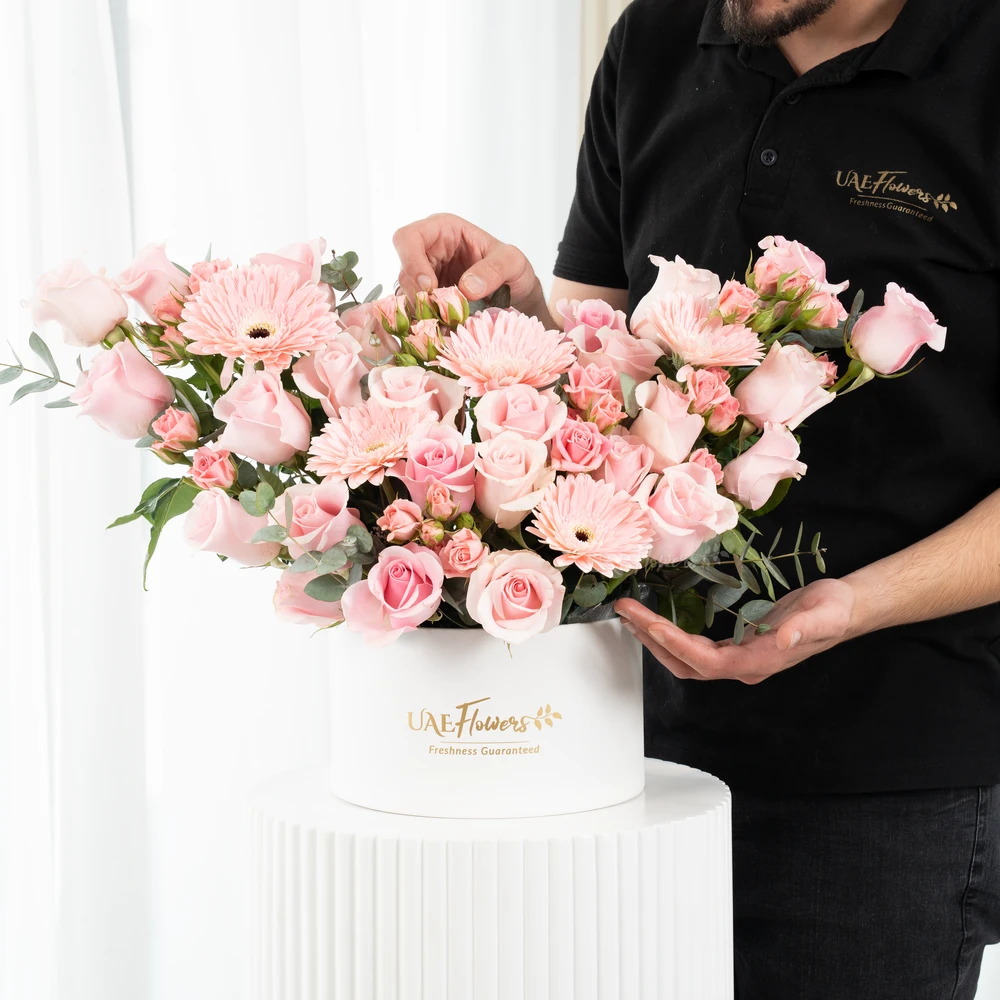 A box arrangement of 5 pink gerberas, 20 pink roses and 3 pink spray roses with green fillers.