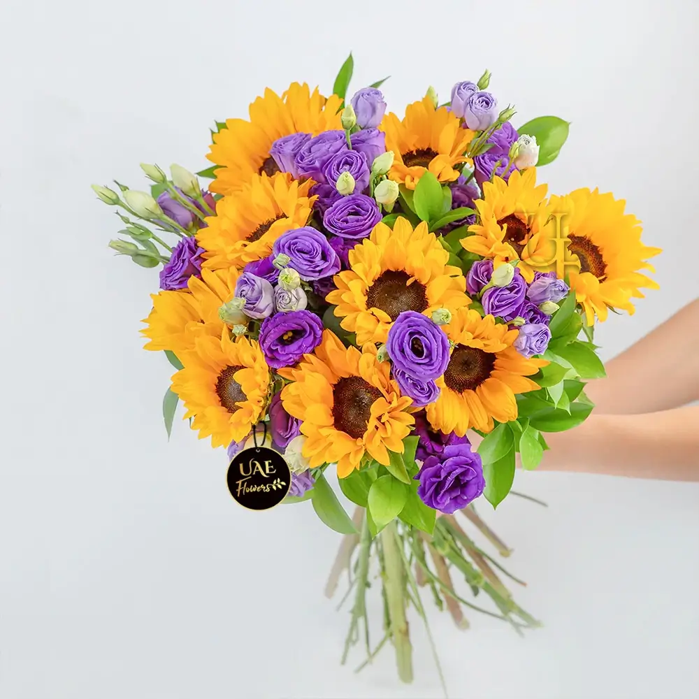 A bouquet of 10 sunflowers, 5 purple spray roses & 15 purple lisianthus, & green fillers tied with ribbon