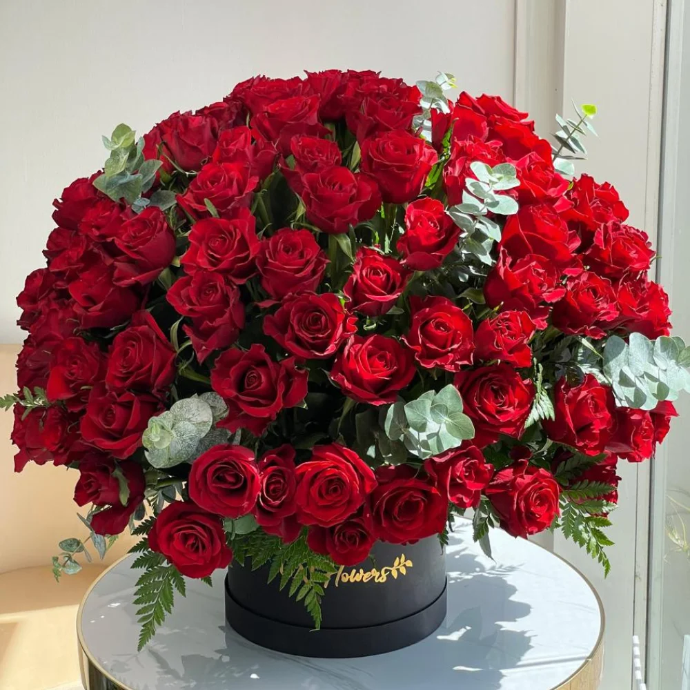 100 red roses box arrangement with eucalyptus in a black box