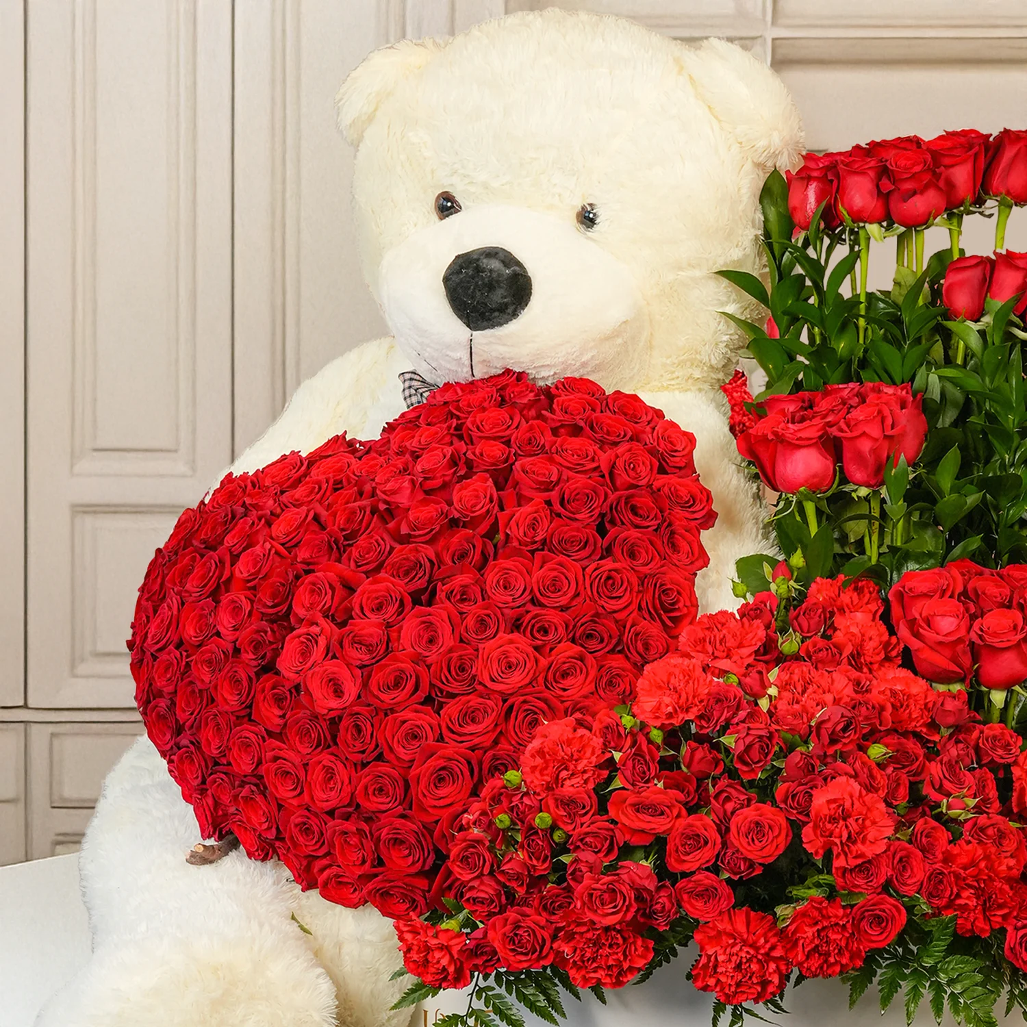 floral heart and box arrangements of 150 red roses with fillers and 1 large white teddy bear.