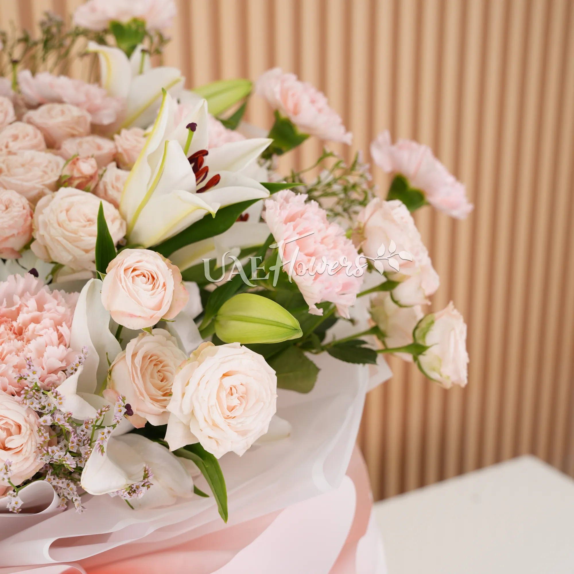5 white lilies, 10 pink carnations, and 10 pink spray roses with green fillers,