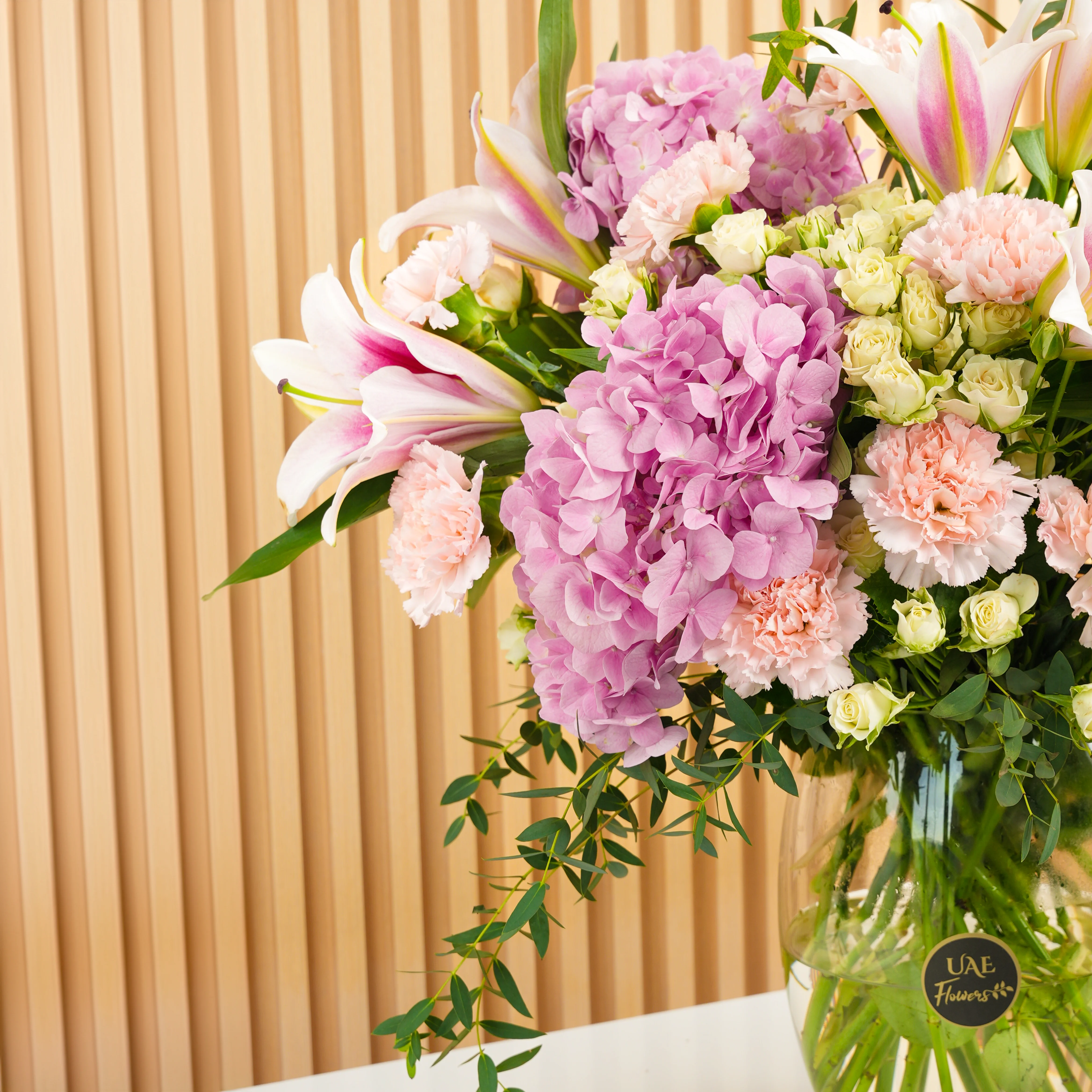 3 pink hydrangeas, 5 pink lilies, 10 pink carnations, and 5 white spray rose