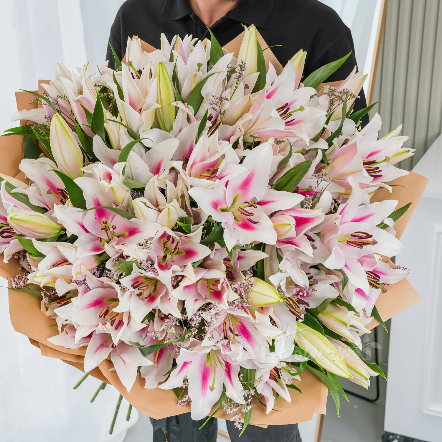 Bouquet of 30 pink lilies elegantly wrapped in premium paper and tied with ribbons – graceful and fragrant floral gift by UAE Flowers.